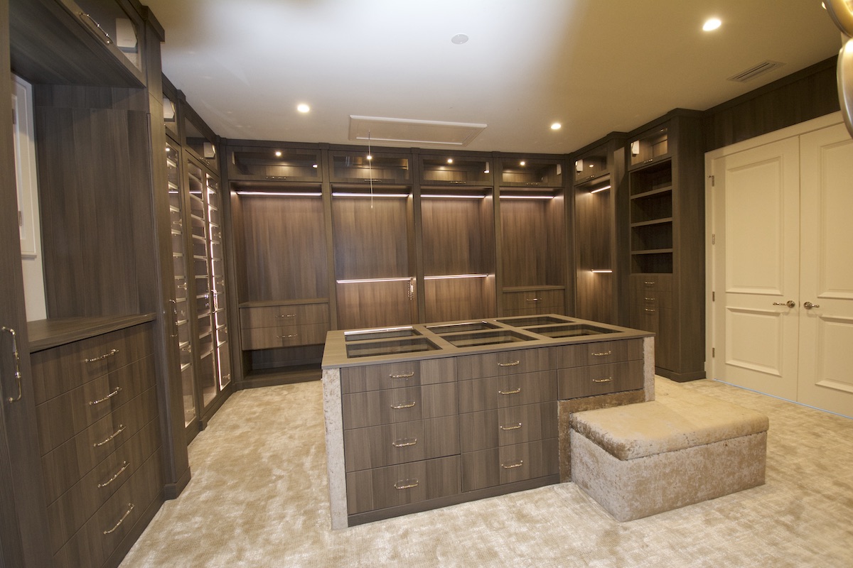Walk-In Closets Tampa, FL A gorgeous carpeted walk-in closet with floor-to-ceiling custom cabinetry.