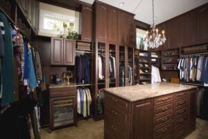 Custom Walk In Closet Land O' Lakes FL Picture of an elegant custom walk-in closet with dark wood cabinetry.
